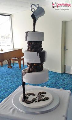 a three tiered cake sitting on top of a table covered in chocolate and nuts