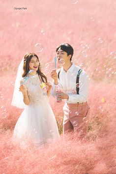 a man and woman standing in a field with bubbles