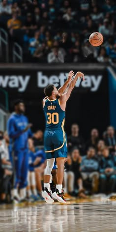 a basketball player is jumping up to dunk the ball in front of an audience