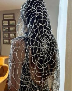 the back of a woman's head covered in chains and beads, with her hair pulled back