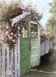 an old wooden shed with flowers growing over it