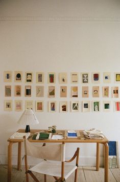 a desk with a lamp and some pictures on the wall