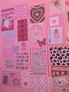 a pink wall covered in lots of different types of paper and stickers on it