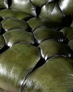 a bunch of green leather couches stacked on top of each other