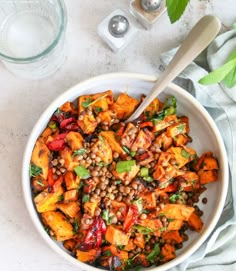 a white bowl filled with lentils and vegetables