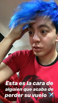 a young man with blue hair wearing a red shirt