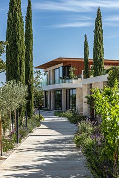 a large house with trees and bushes around the front entrance to it's driveway