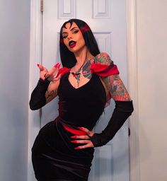 a woman dressed in black and red posing for the camera