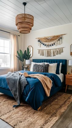 a bedroom with blue bedding, pillows and blankets on top of the bedspread