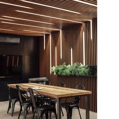 a wooden table and chairs in a room with wood slats on the wall behind it