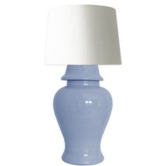 a light blue lamp with a white shade on the top and bottom, against a white background