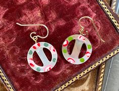 two pairs of earrings sitting on top of a velvet bag