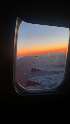 the view out an airplane window at sunset