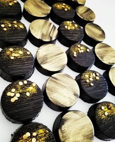 some black and gold decorated cookies on a white table