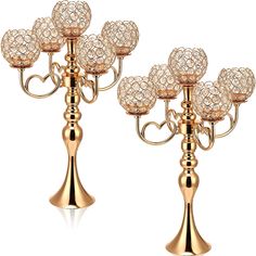 two gold candelabra with crystal balls on each candle holder and one has a heart