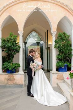 a bride and groom standing in front of an archway at the entrance to their wedding venue