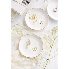 two plates with the letters k and m on them next to some baby's breath flowers