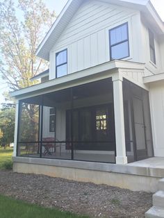 a large white house with lots of windows on it's front porch and stairs leading up to the second floor