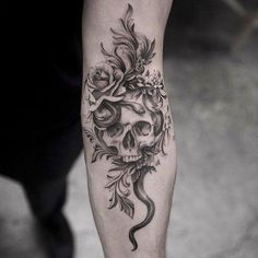 a man's leg with a skull and flowers on it