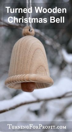 a wooden bell ornament hanging from a tree branch with the words turned wooden christmas bell