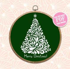 a cross stitch christmas tree on a green background with the words merry christmas written in white