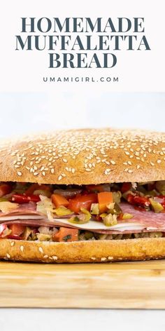 a close up of a sandwich on a cutting board with the words homemade muffaletta bread