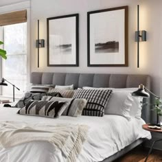 a large bed sitting in a bedroom next to a window with two framed pictures on the wall