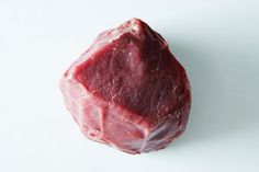 a piece of raw meat sitting on top of a white table