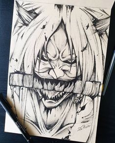 a drawing of a creepy clown with teeth and fangs on it's face, next to a marker pen