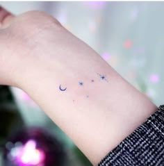 a small wrist tattoo with stars and crescents on the left side of the arm