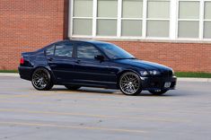 a blue car parked in front of a brick building