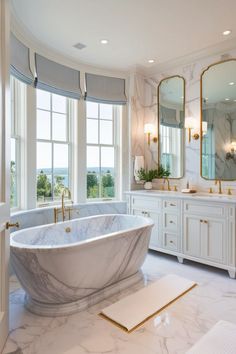 a marble bathtub sits in the middle of a large bathroom