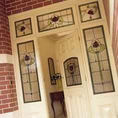 an open door with stained glass panels on the front and side doors to another room