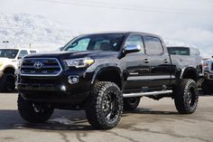 a black toyota truck parked in a parking lot