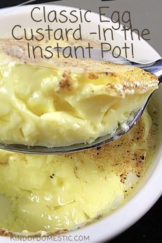 a white bowl filled with mashed potatoes on top of a black table next to a spoon