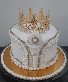 a white cake with gold trim and a crown on top