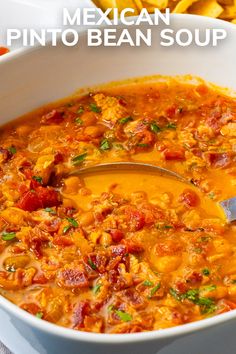 mexican pinto beans soup in a white bowl with a spoon