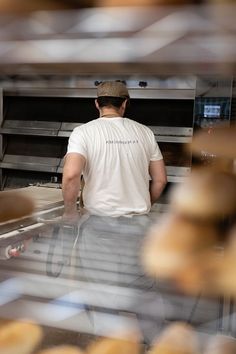 a man walking through a bakery filled with donuts