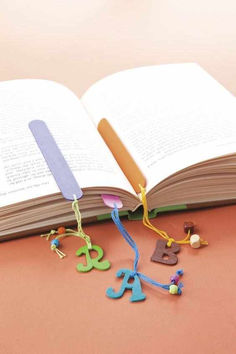 an open book sitting on top of a table next to some beads and magnets