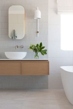 a bathroom with two sinks, a mirror and a bathtub in the middle of it