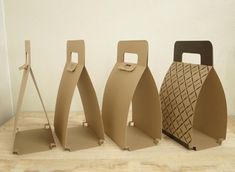 three pieces of cardboard sitting next to each other on a wooden table with a white wall in the background