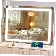 a mirror that is sitting on top of a dresser in front of a window with lights