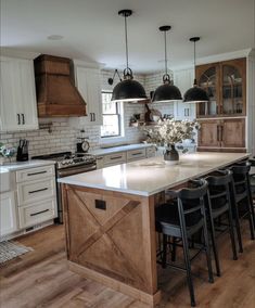 a large kitchen with an island in the middle and lots of chairs at the end