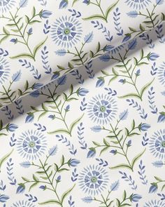 a blue and green floral print on white fabric, with small flowers in the center