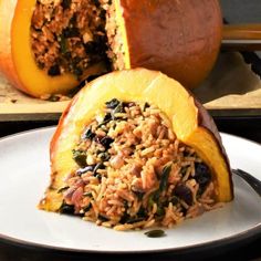 a white plate topped with a stuffed pumpkin filled with rice