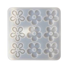 a plastic mold that has flowers on the front and side of it, in white