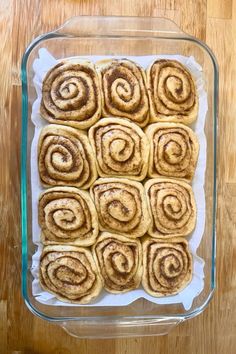 cinnamon rolls in a glass baking dish on a wooden table