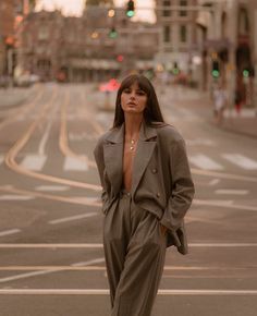 a woman standing in the middle of an empty street with her hands on her hips