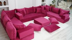 a living room filled with pink couches and pillows