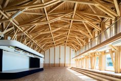 an empty room with wooden beams and windows on either side of the room is a stage